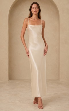 Vestido de invitada formal elegante color champán con tirantes finos y corte minimalista en satén.