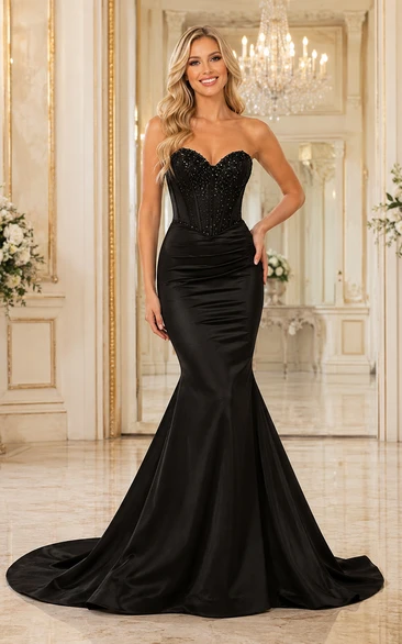 Robe sirène bustier en satin noir avec corset en forme de cœur orné de perles, idéale pour les soirées de bal et les réceptions formelles.