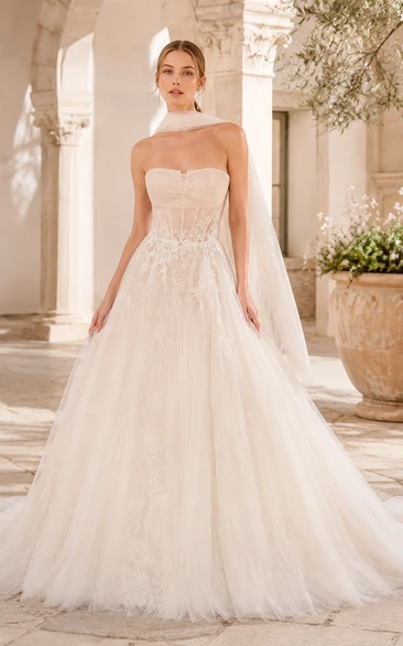 Vestido de novia de gala de tul con corpiño de encaje sin tirantes y cola de capilla.
