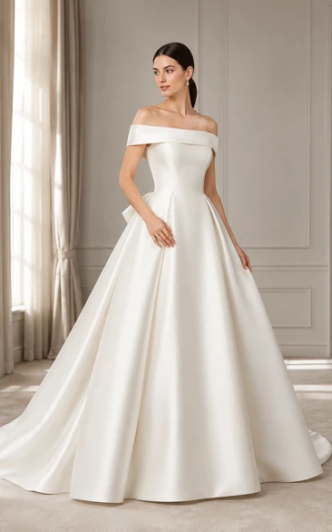 Vestido de novia de satén con escote de hombros descubiertos y cola con lazo en la espalda.