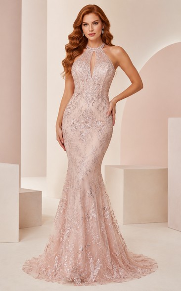 Robe de soirée sirène rose poudré à dos nu, ornée de perles, avec décolleté en V plongeant et dos nu.