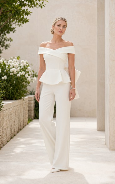 Mono de novia blanco con peplum, hombros descubiertos y lazo en la espalda.