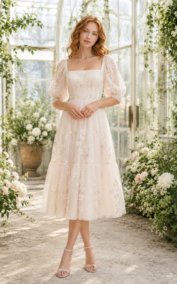 Robe de mariée mi-longue à encolure carrée, manches bouffantes transparentes et jupe en dentelle