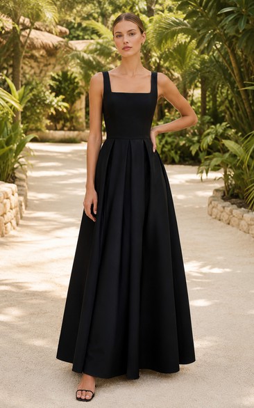 Robe de demoiselle d'honneur noire en satin, coupe trapèze, col carré et jupe ample.