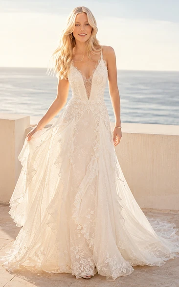 Vestido de novia bohemio de corte A con encaje, tirantes en V y cola de capilla.