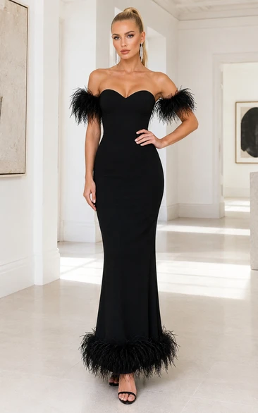 Vestido formal negro sin tirantes estilo sirena con ribete de plumas en las mangas y dobladillo de plumas.