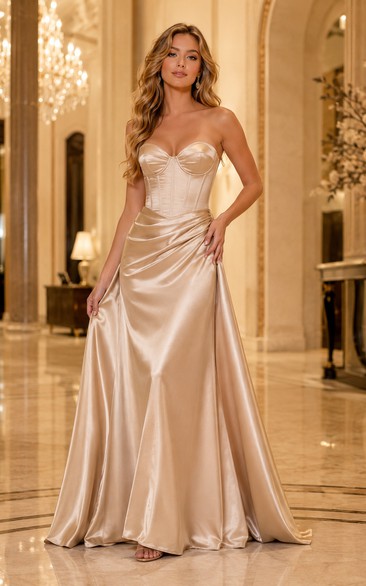 Vestido de noche de satén drapeado sin tirantes color champán con cola.