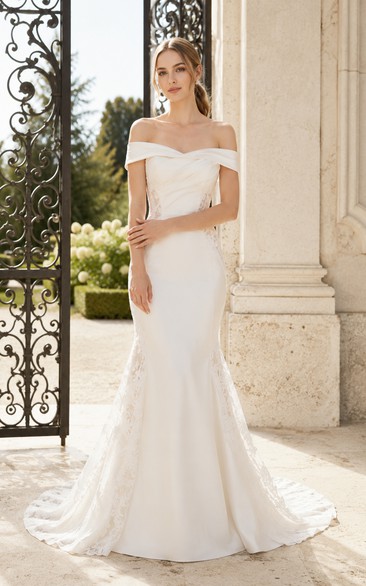 Vestido de novia sencillo de encaje estilo sirena con hombros descubiertos y cola larga.