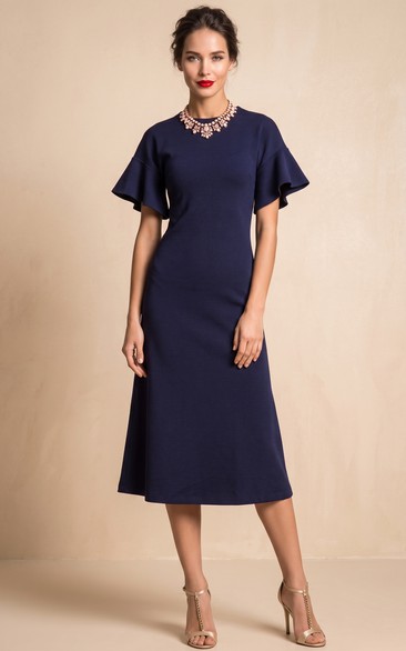 Vestido de punto de corte A, largo hasta la rodilla, con cuello alto y mangas cortas acampanadas.