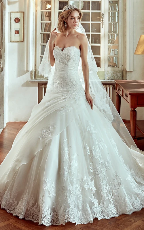Vestido de novia de corte A con escote corazón, drapeado lateral y bordados.