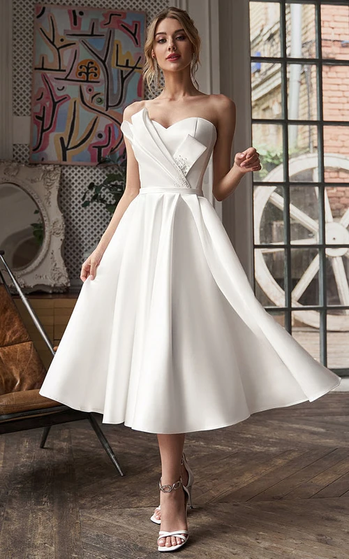 Vestido de novia corto de satén con escote corazón, corte en A, largo hasta la rodilla, drapeado y detalles de pedrería.