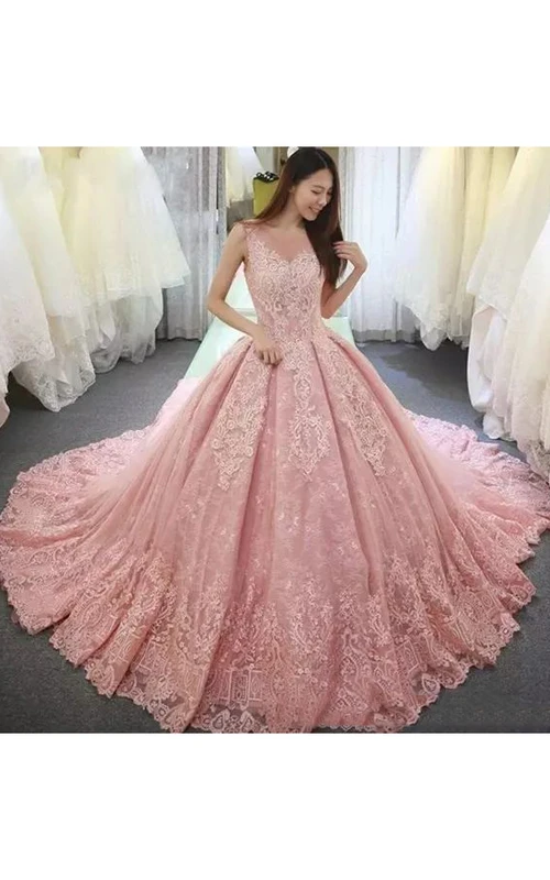 Vestido de novia de gala con escote en V, mangas tres cuartos, cola larga y encaje y tul.