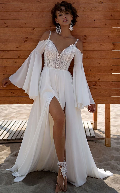 Vestido de novia de playa estilo bohemio con tirantes finos, corte imperio y abertura frontal de gasa.