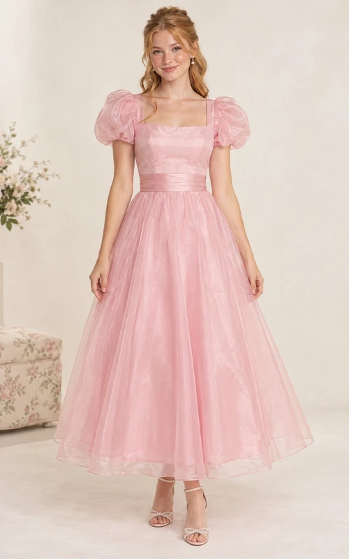 Vestido de fiesta de corte A de tul color rosa empolvado con escote cuadrado y mangas abullonadas, largo hasta la rodilla.