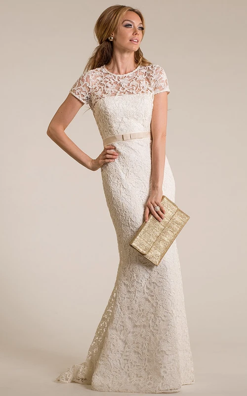 Robe de mariée vintage en dentelle, coupe fourreau, col montant, manches courtes et effet illusion.