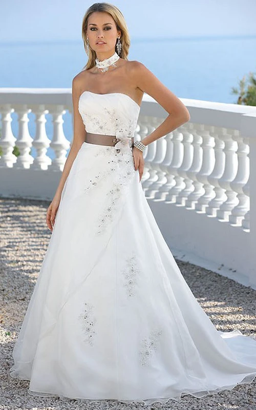Robes de mariée bustier en satin et tulle, style trapèze, ornées de perles, de fleurs et de rubans.