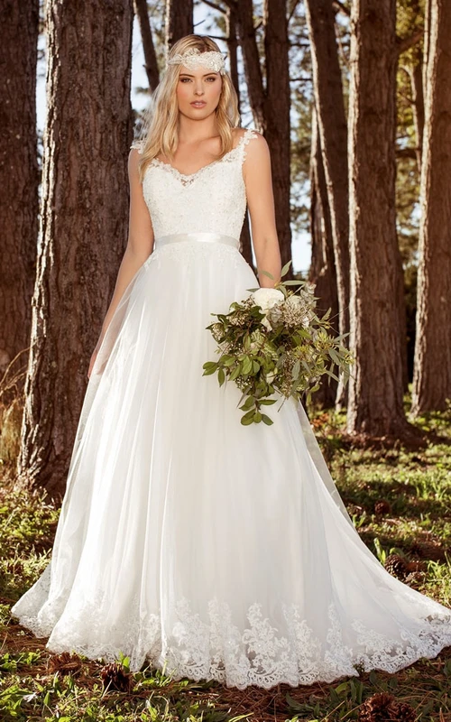 Vestido de novia sencillo estilo bohemio con tirantes, cola de corte A y apliques.