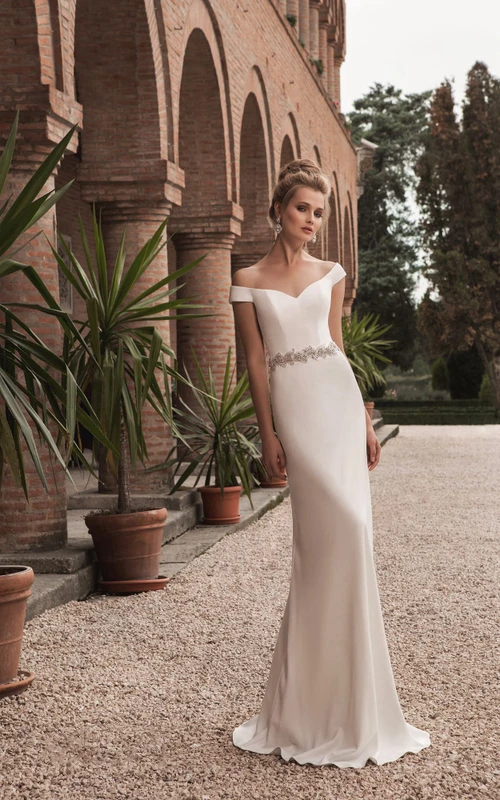 Vestido tubo con escote en V y hombros descubiertos, decorado con cristales.