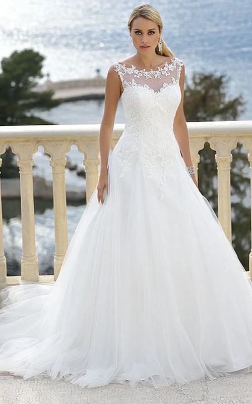 Vestido de novia largo hasta el suelo con apliques de tul, cola de corte y efecto ilusión.