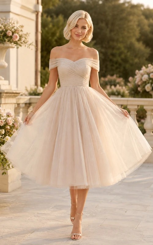 Vestido de invitada de boda romántico de tul color marfil con hombros descubiertos y mangas cortas, corte en A y largo hasta la rodilla.