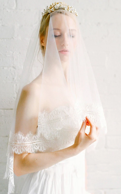 Voile de mariée en tulle bordé de dentelle, longueur bout des doigts.