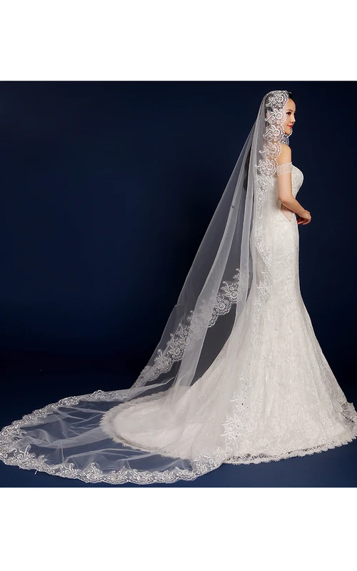 Magnifique voile de mariée long en tulle bordé de dentelle, idéal pour une cérémonie à la chapelle.