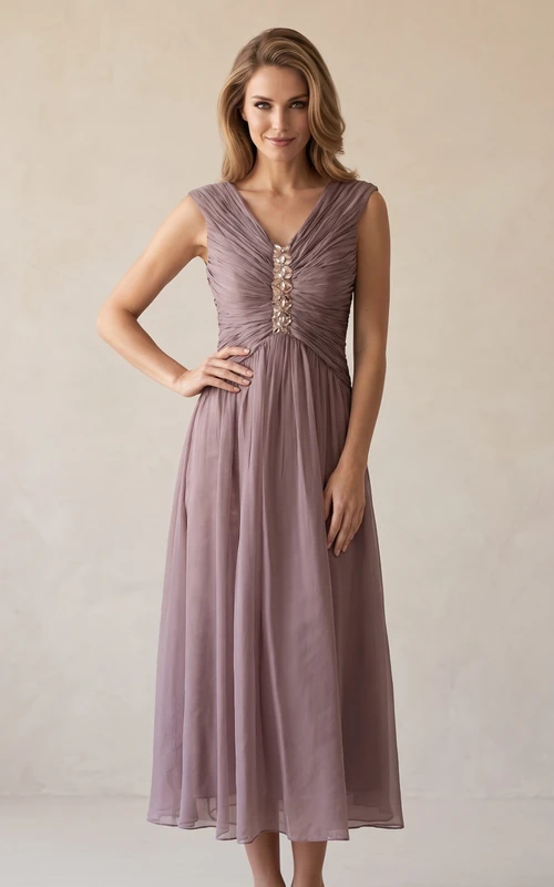 Vestido largo de gasa con escote en V, mangas cortas y corte en A con detalles de pedrería.