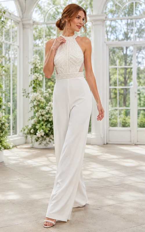 Mono de novia con escote halter, espalda con abertura y cinturón de cuentas.