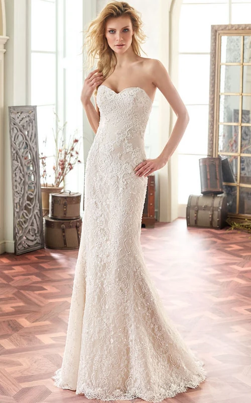Robe de mariée longue en dentelle perlée avec décolleté en V et traîne.