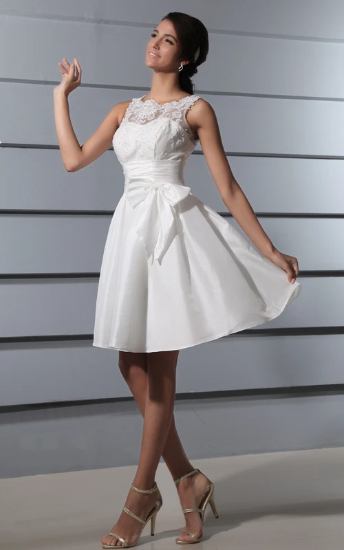 Robe courte en dentelle à dos nu plongeant, avec ceinture et nœud.