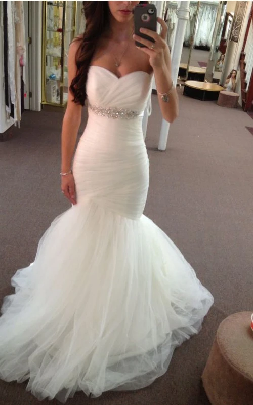 Vestido de novia de tul estilo sirena con escote corazón y fruncido.