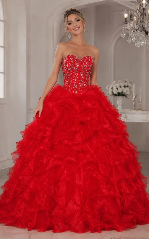 Vestido de gala largo hasta el suelo con volantes, pedrería y corsé en la espalda, de organza y encaje.
