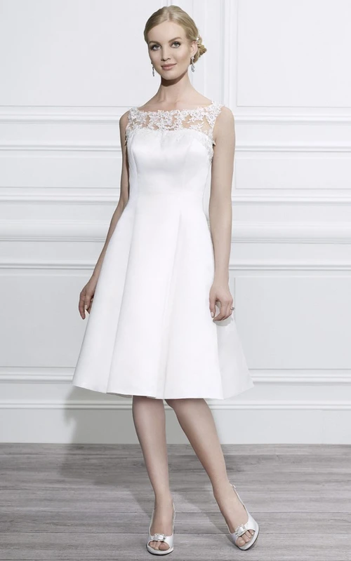Robe de mariée en satin à encolure bateau, longueur genou, ornée d'appliqués et d'illusion.