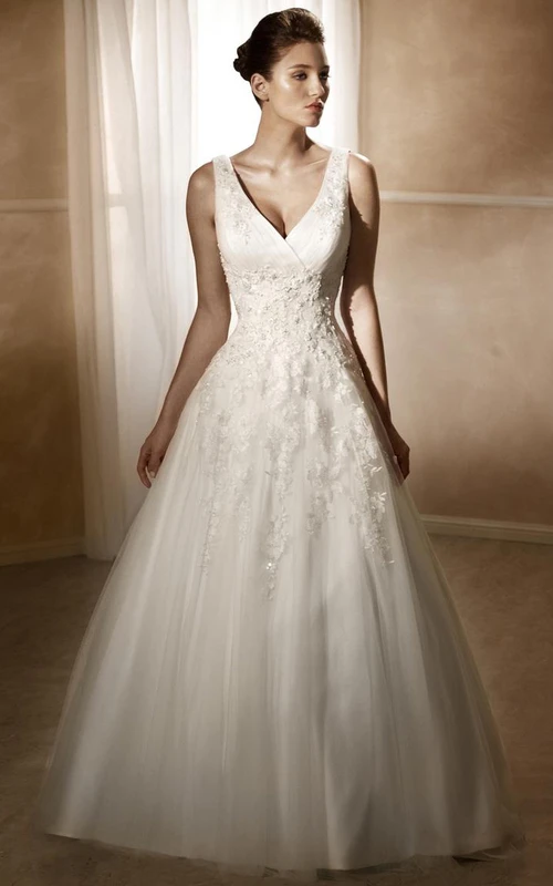 Vestido de novia largo sin mangas con escote en V, corte en A, apliques de satén y tul, cola de corte y espalda baja en V.