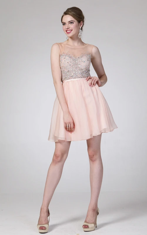Vestido corto de gasa sin mangas con escote redondo y corte en A, con efecto ilusión y detalles de pedrería.
