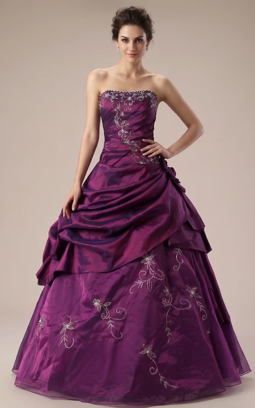 Robe de bal à bretelles longues, plissée, ornée de perles et de broderies, à volants et laçage au dos. Robe en dentelle, organza et satin.