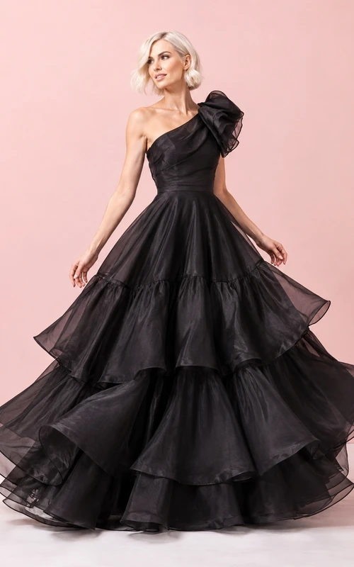 Vestido de gala negro de tul con un solo hombro, sin mangas y con volantes.