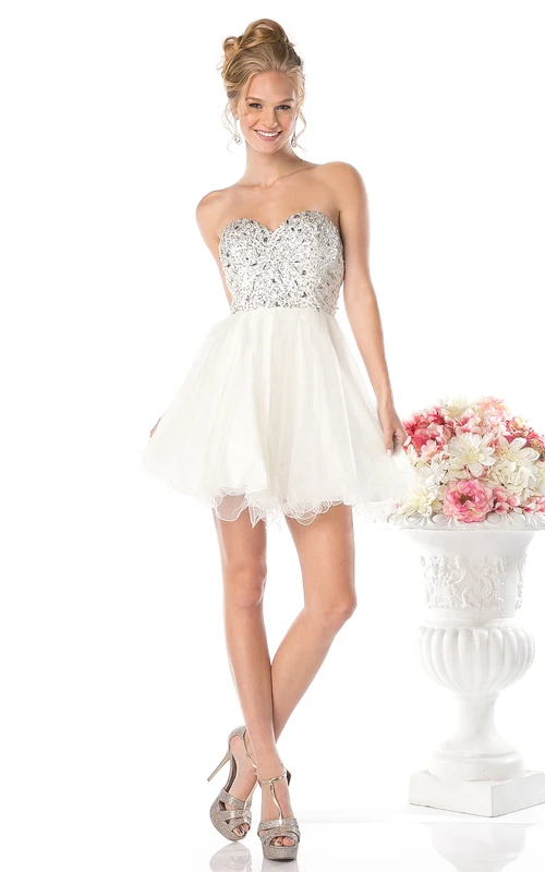 Vestido corto sin mangas con escote corazón, espalda descubierta, corte en A, con abalorios y volantes.
