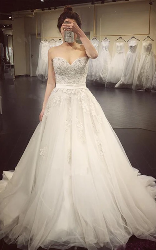 Elegantes vestidos de novia de corte A con escote corazón, apliques de cuentas y cola de corte princesa.