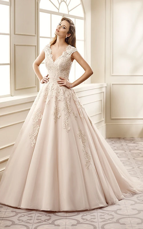 Robe de mariée longue en dentelle plissée, coupe trapèze, col en V orné d'appliqués et manches courtes.