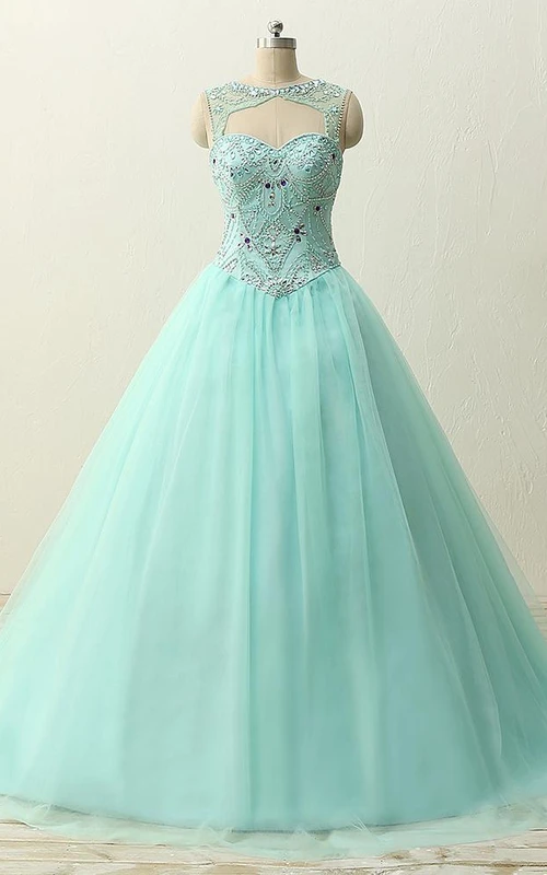 Robe en tulle, dentelle et satin à bretelles longues et décolleté cœur orné de perles et de franges.