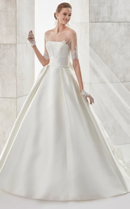 Vestido de novia de satén sin tirantes, corte en A, con abrigo desmontable de encaje ilusión y lazo en la espalda.