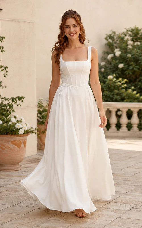 Robe de mariée longue en mousseline, col carré, sans manches, corsage à coutures apparentes, taille naturelle, dos nu à bretelles, coupe trapèze.