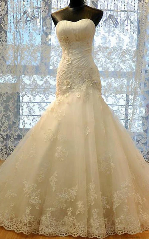 Robe sirène à décolleté cœur, plis cloche, perles et appliques, fermeture éclair et laçage au dos, en mousseline, tulle, dentelle, sequins, organza, satin et taffetas.