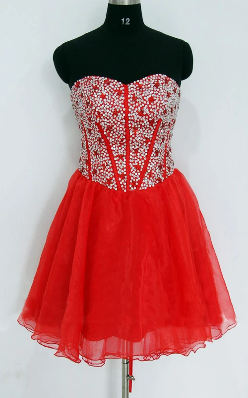 Vestido corto de gasa y satén con escote corazón y lentejuelas.