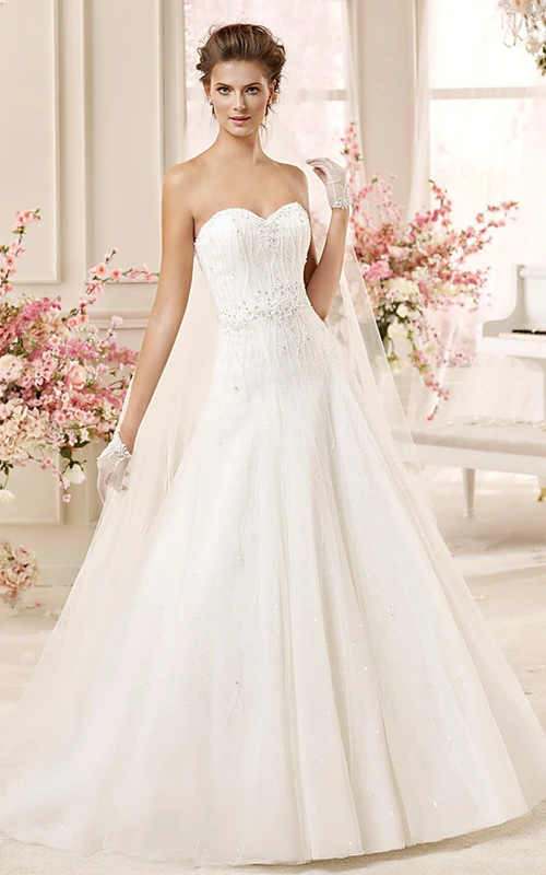 Vestido de novia de corte A con escote corazón, bordados, falda plisada y espalda con cordones.