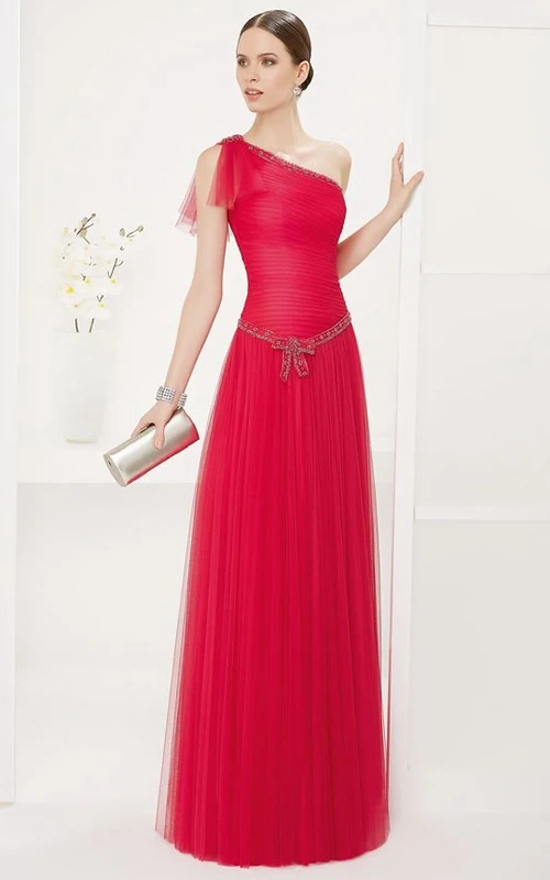 Vestido largo de fiesta asimétrico de tul con talle bajo y escote y cintura de cristal.