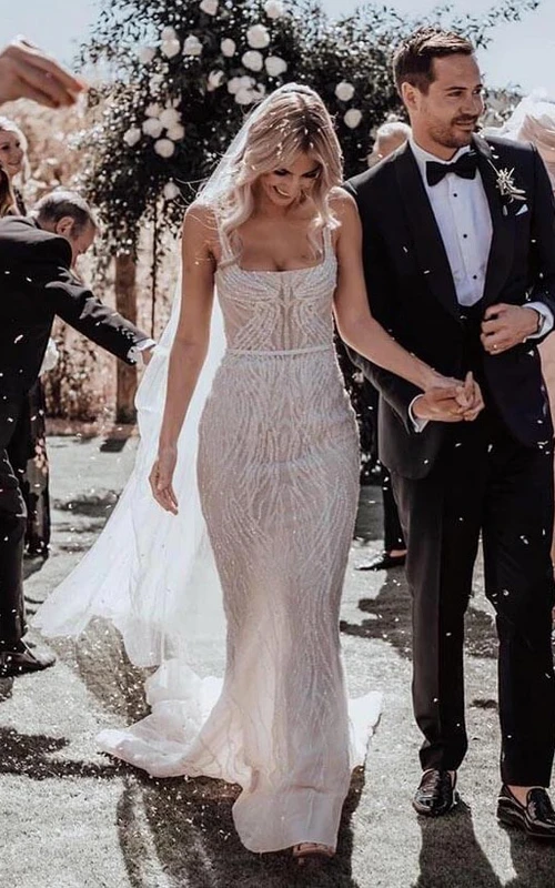 Robe de mariée bohème luxueuse, dos nu, fourreau spaghetti orné de perles et traîne courte.