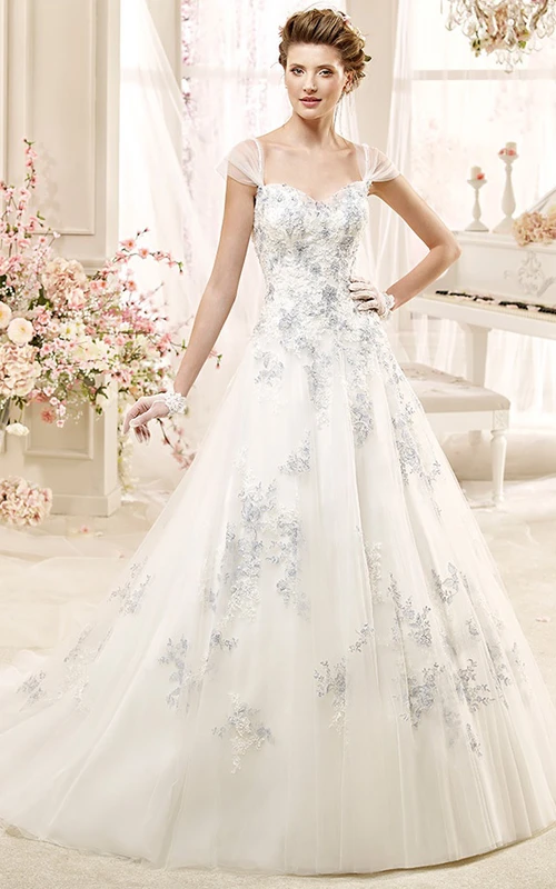 Vestido de novia romántico de corte A con escote corazón, flores abalorios y cola de cepillo.