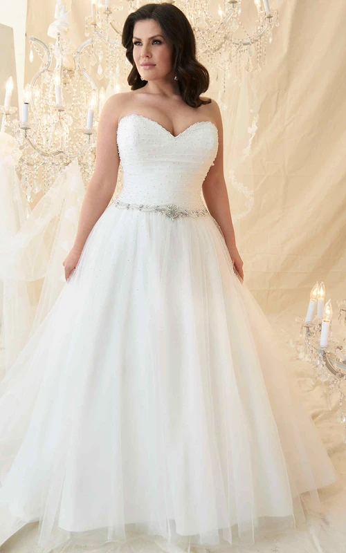 Vestido de novia largo de tul con escote corazón, sin mangas, corte en A, con cuentas y joyas en la cintura.